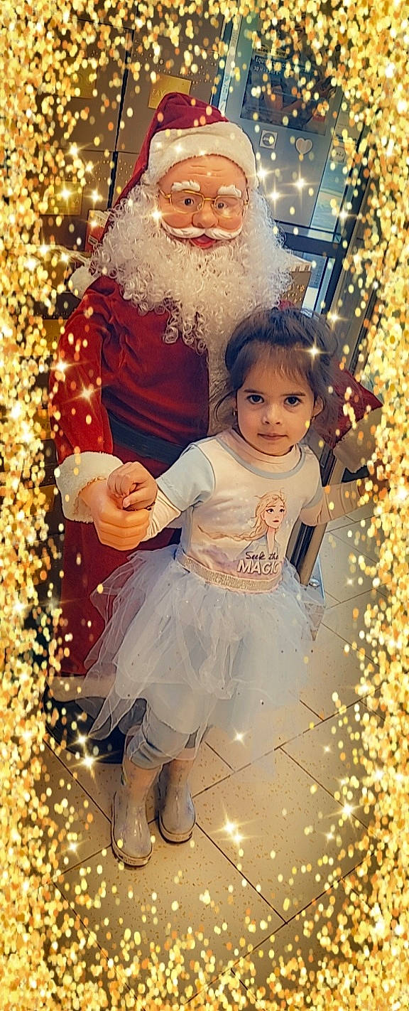 Calyssa a rejoint le concours — aidez-le/la à gagner de superbes lots ! baby_toddler_clothing, beard, christmas_ornament, christmas_tree, dress, eye, facial_expression, fun, happy, holiday_ornament, human, human_body, light, ornament, outerwear, people, people_in_nature, person, standing, toddler