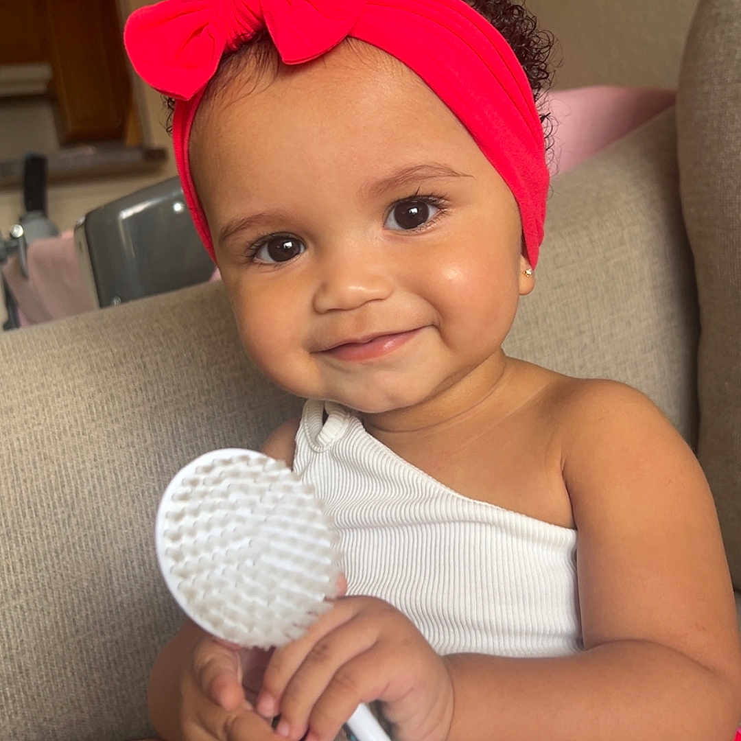 Zilyncia joined the competition — help win amazing prizes! baby, brush, child, couch, curly_hair, cute, earrings, face, hand, happy, headband, indoor, portrait, red_bow, sitting, skin, smiling, striped_skirt, toddler, white_top