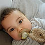 James participe au concours pour gagner de l'argent avec cette photo : baby, pacifier, teddy_bear, striped_pajamas, cute, close_up, infant, child, cuddly, soft_toy, sleepwear, portrait, indoors, comfort, relaxation, hand, skin, face, eyes, expression