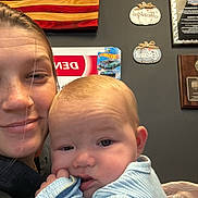 Kacey joined the competition — help win amazing prizes! baby, infant, woman, selfie, portrait, cuddle, indoor, american_flag, wall_decor, plaque, hot_wheels, toy_car, blanket, clothing, face, hand, cozy, parent, smiling, closeup