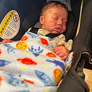 Isaiah joined the competition — help win amazing prizes! infant, baby, sleeping, blanket, car_seat, child, face, hand, seatbelt, soft_lighting, indoors, colorful_blanket, peaceful, resting, cozy, cute, portrait, newborn, safety, car