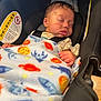 infant, baby, sleeping, blanket, car_seat, child, face, hand, seatbelt, soft_lighting, indoors, colorful_blanket, peaceful, resting, cozy, cute, portrait, newborn, safety, car