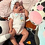 baby, infant, headband, bow, onesie, plush_toy, cow_plush, pink_blanket, soft_toy, cute, child, indoors, lying_down, expression, surprised, small_person, cozy, comfort, toddler, home