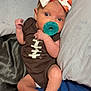 Raelynn joined the competition — help win amazing prizes! baby, infant, pacifier, bow, football, onesie, pillow, blanket, bed, sleepwear, foot, hand, cute, lying_down, indoors, soft, newborn, child, resting, skin