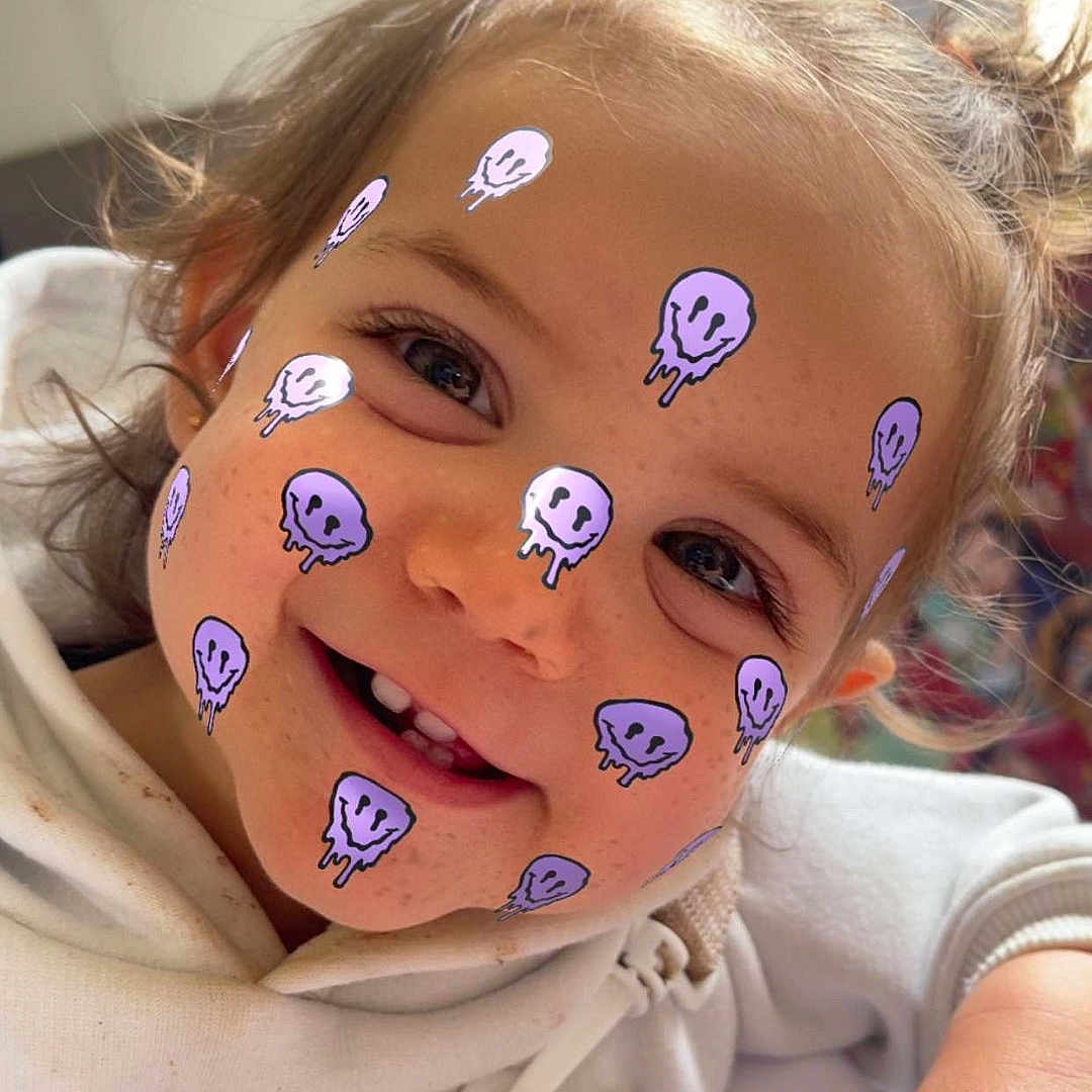 Raven a rejoint le concours — aidez-le/la à gagner de superbes lots ! casual_clothing, child, childhood, closeup, cute, expression, face_filter, freckles, hair, hand, happy, harness, hoodie, indoor, person, playful, portrait, smile, toddler, young_child