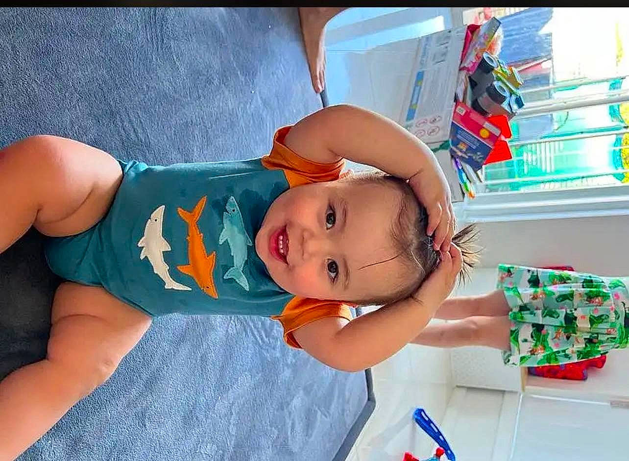 Malik is registered to the contest to win money with this photo: abdomen, arm, baby, baby_products, baby_toddler_clothing, child, elbow, electric_blue, finger, fun, hand, happy, hat, leisure, mouth, person, room, smile, textile, thigh