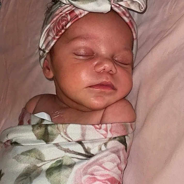 Amilyah joined the competition — help win amazing prizes! newborn, baby, sleeping, infant, portrait, face, headband, bow, swaddled, blanket, floral, roses, pink, bed, bedding, indoors, peaceful, closed_eyes, resting, photography
