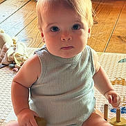 Timéo a rejoint le concours — aidez-le/la à gagner de superbes lots ! baby, child, infant, sitting, toy, play_mat, wooden_floor, natural_light, indoors, cute, chubby, face, hand, clothing, tank_top, expressionless, curious, hair, person, skin