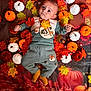 baby, infant, autumn, fall_leaves, pumpkins, plush_toys, milestone_badge, clothing, socks, cute, portrait, seasonal, decor, orange, white, red, green, indoor, child, face