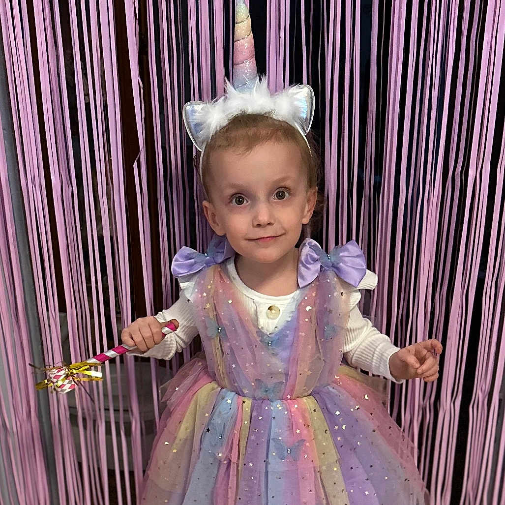 Cora is registered to the contest to win money with this photo: child, clothing, costume, dress, face, female, food, footwear, formalwear, girl, hat, head, people, person, photography, portrait, purple, sandal, shoe, sweets