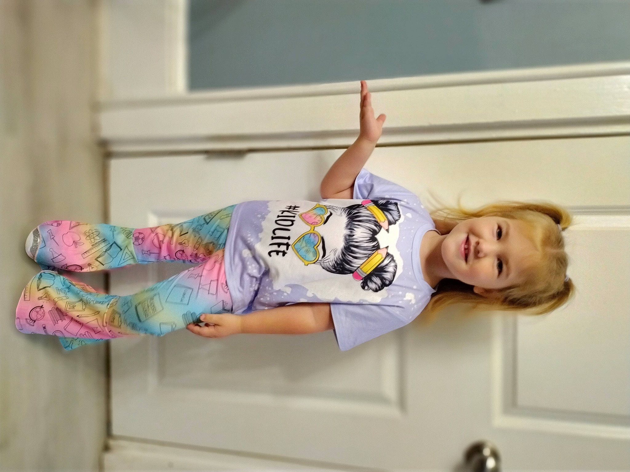 Abigail is registered to the contest to win money with this photo: baby_toddler_clothing, child, fashion_design, fun, happy, human_leg, joy, knee, pattern, person, room, sitting, sleeve, smile, sportswear, t_shirt, thigh, toddler, waist