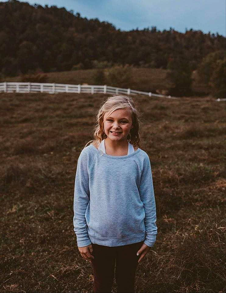 Amber is registered to the contest to win money with this photo: ecoregion, flash_photography, grass, grassland, hair, happy, head, joy, leaf, mammal, people, people_in_nature, person, plant, sky, sleeve, standing, sunlight, t_shirt, tree