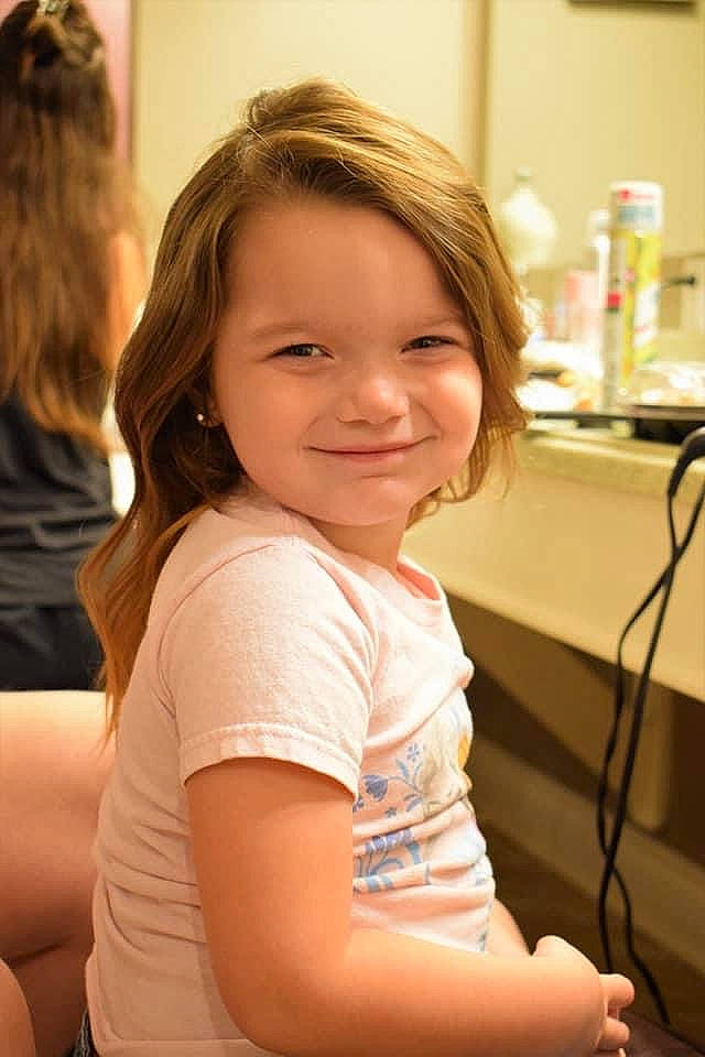 Priscilla is registered to the contest to win money with this photo: arm, blond, child, chin, hair, joy, leg, long_hair, person, shoulder, sitting, smile