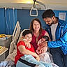Myriam a rejoint le concours — aidez-le/la à gagner de superbes lots ! bed, blanket, candy, child, family, father, food, happy, holding, hospital_room, indoor, man, medical_equipment, mother, newborn, person, smiling, together, tray, woman