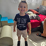 Eden a rejoint le concours — aidez-le/la à gagner de superbes lots ! child, toddler, smiling, indoor, casual_clothing, shorts, sneakers, curtains, couch, blanket, floor, window, toy, footwear, person, happy, hairstyle, living_room, home, sunlight