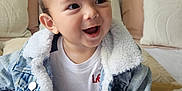 Emiliano joined the competition — help win amazing prizes! toddler, child, smiling, denim_jacket, sneakers, bed, pillow, indoor, happy, cute, clothing, person, footwear, pants, baby, sitting, face, casual, room, young_child