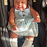 baby, infant, child, portrait, car_seat, sitting, dress, blue_dress, white_bows, hair_bows, socks, smiling, facial_expression, indoor, sunlight, vehicle, safety_seat, fashion, wood_floor, photograph
