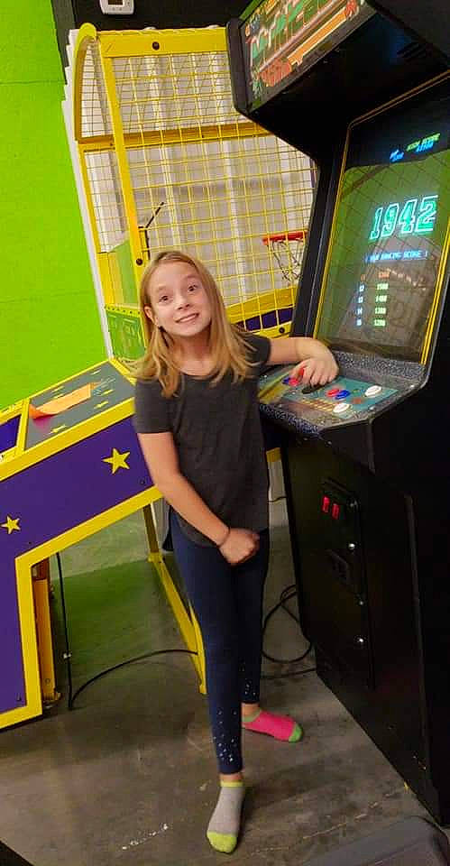 Alexis is registered to the contest to win money with this photo: air_hockey, arcade_game, electronic_device, fun, games, indoor_games_and_sports, joy, machine, person, play, recreation, recreation_room, room, standing, technology, video_game_arcade_cabinet