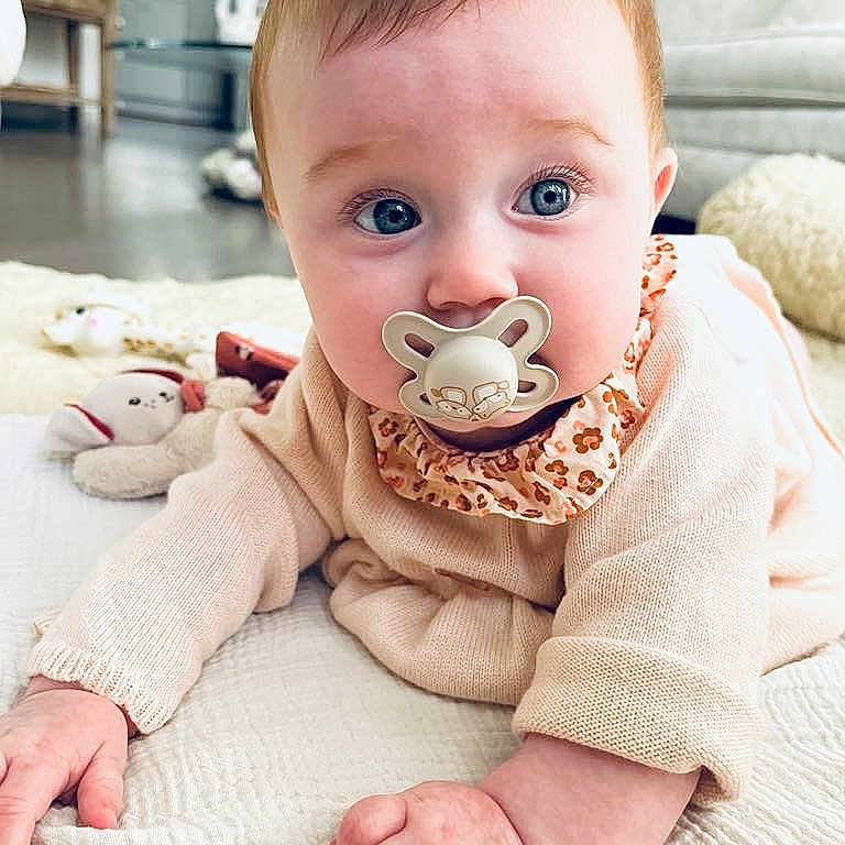 Hilda participe au concours pour gagner de l'argent avec cette photo : baby, blanket, blue_eyes, carpet, child, clothing, cozy, crawling, curious, cute, face, furniture, hand, indoor, infant, living_room, pacifier, person, plush_toy, soft_lighting