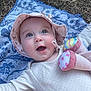 Hilda a rejoint le concours — aidez-le/la à gagner de superbes lots ! baby, blue_eyes, child, cute, expression, face, floral, grass, happy, hat, infant, lying_down, nature, outdoors, plush, smile, sunhat, towel, toy, white_clothing