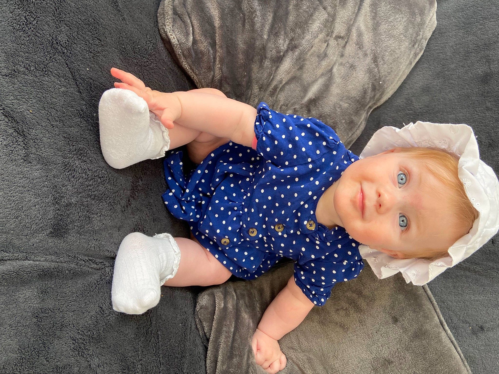 Léana participe au concours pour gagner de l'argent avec cette photo : baby, baby_toddler_clothing, child, comfort, elbow, electric_blue, finger, fun, gesture, grass, human_leg, knee, linens, pattern, person, sitting, sleeve, sock, thigh, toddler