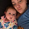 Everleigh is registered to the contest to win money with this photo: baby, adult, pajamas, cartoon_characters, blue_shirt, sunflower, portrait, indoor, closeup, face, person, child, sleepwear, cute, looking_at_camera, lying_down, parent_and_child, skin, head, expression