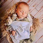 Caleb joined the competition — help win amazing prizes! baby, sleeping, blanket, stuffed_animal, overalls, fur_cushion, wooden_floor, infant, peaceful, child, cute, soft_toy, cozy, portrait, resting, indoor, newborn, comfort, clothing, hands