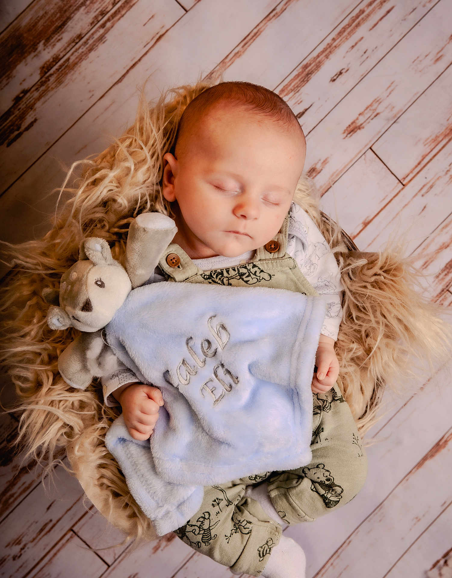 Caleb joined the competition — help win amazing prizes! baby, sleeping, blanket, stuffed_animal, overalls, fur_cushion, wooden_floor, infant, peaceful, child, cute, soft_toy, cozy, portrait, resting, indoor, newborn, comfort, clothing, hands