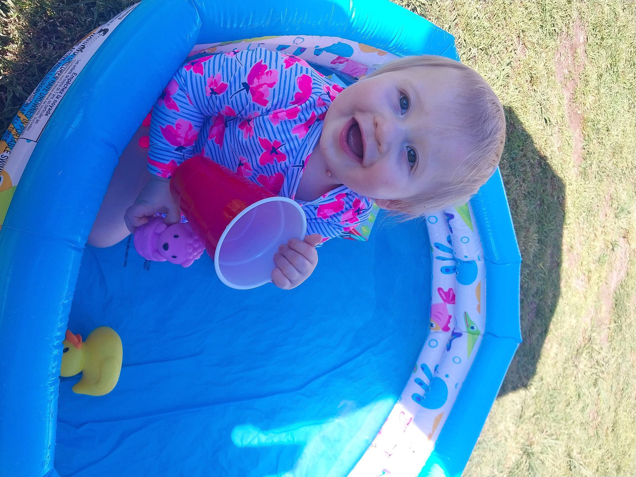 Emmalyn is registered to the contest to win money with this photo: azure, baby_products, baby_toddler_clothing, blue, child, circle, electric_blue, fun, grass, happy, hat, inflatable, joy, leisure, person, plastic, play, recreation, smile, toddler