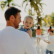 Louis a rejoint le concours — aidez-le/la à gagner de superbes lots ! child, toddler, man, family, beach, palm_trees, sunlight, outdoor, summer, vacation, casual_clothing, people, sand, nature, portrait, smile, happy, walking, holding, daylight