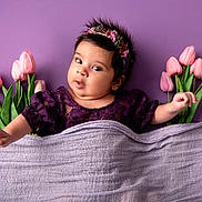 Savreen Kaur is registered to the contest to win money with this photo: adorable, baby, blanket, child, chubby_cheeks, closeup, clothing, curious_expression, cute, floral, flower_crown, headband, indoor, infant, laying_down, lilac, pink_tulips, portrait, purple_background, soft_texture