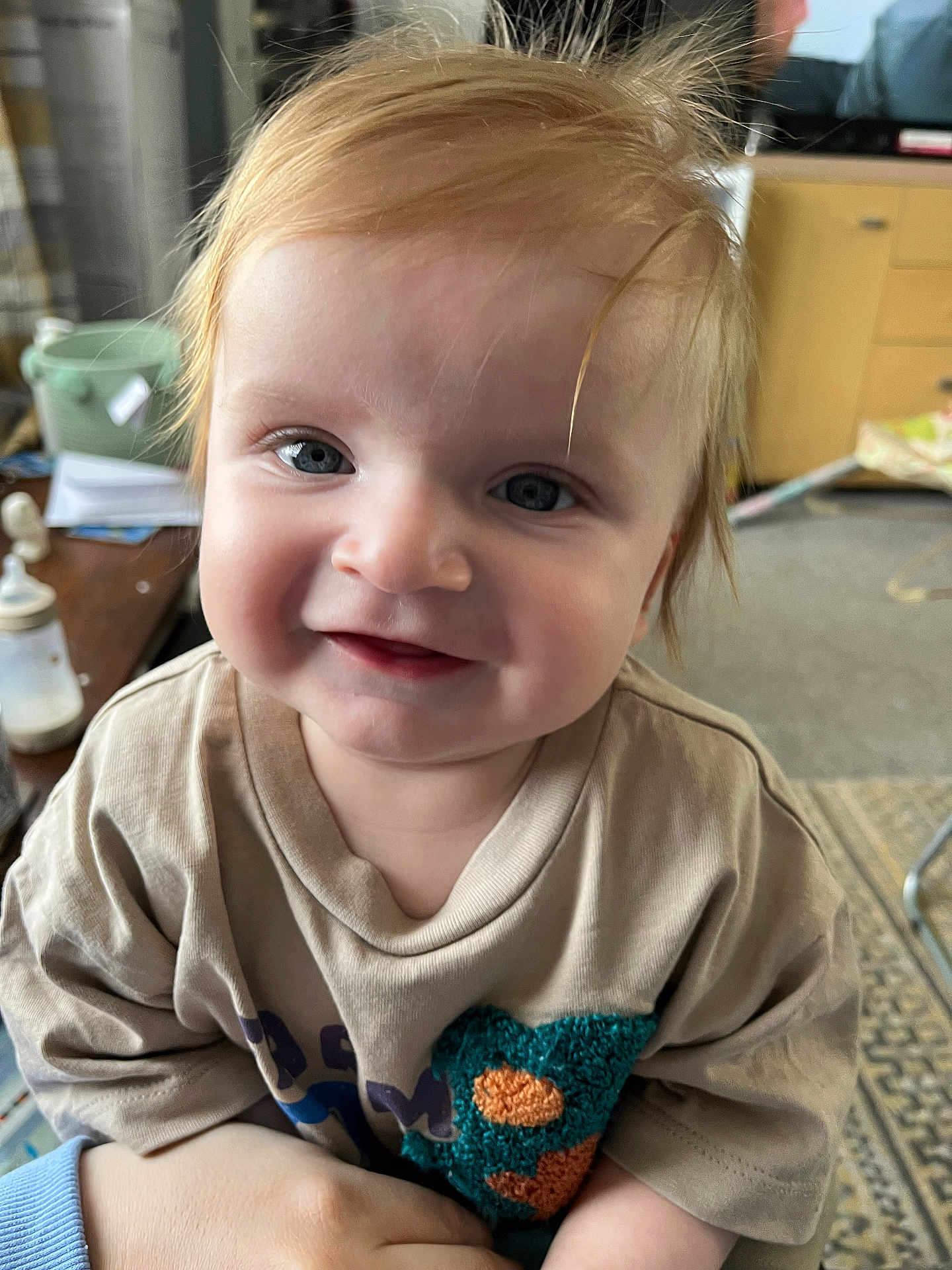 Thomas joined the competition — help win amazing prizes! baby, child, smiling, face, blue_eyes, red_hair, indoor, shirt, clothing, person, closeup, cute, happy, infant, portrait, hand, furniture, carpet, table, bottle