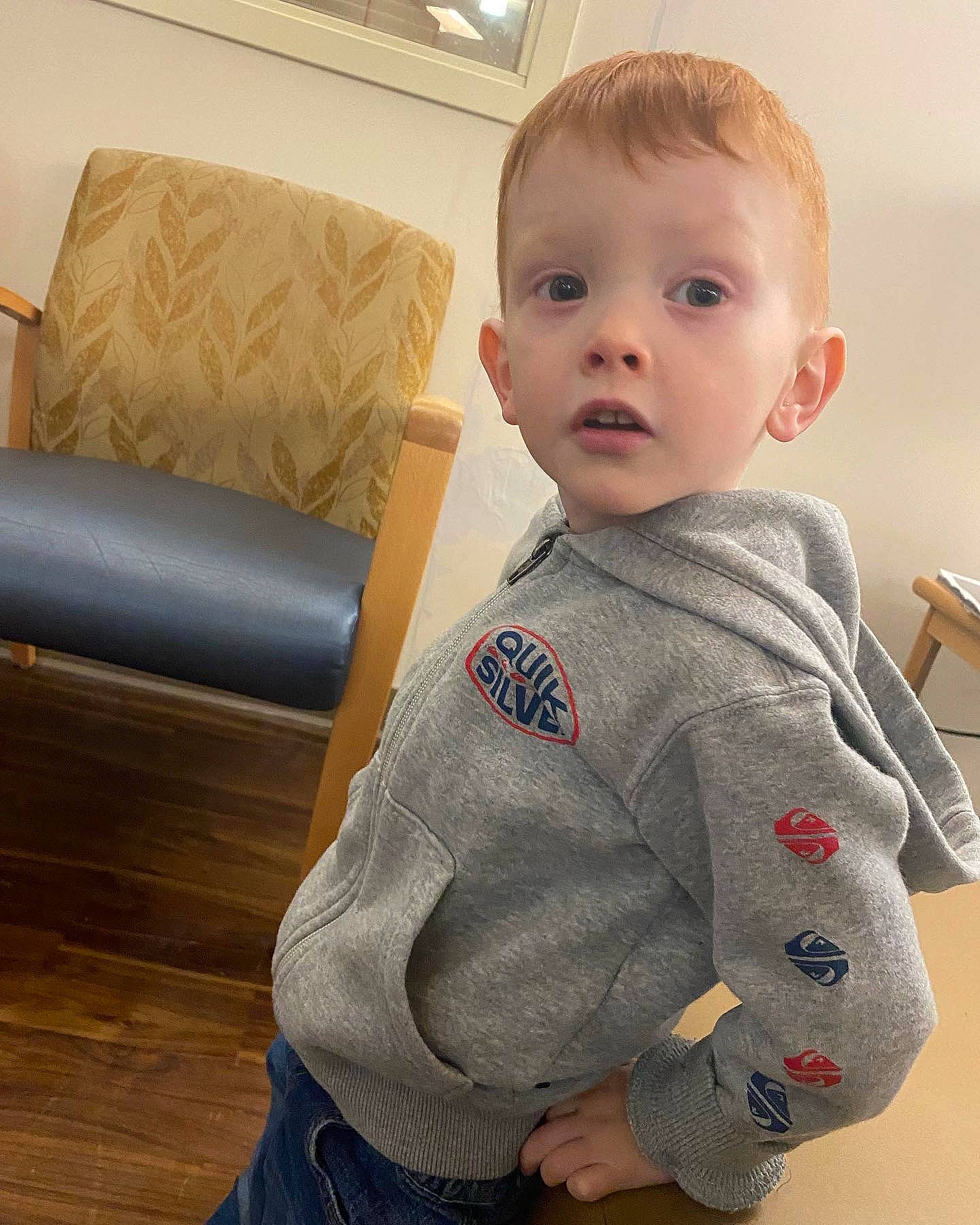 Atreyu is registered to the contest to win money with this photo: baby, baby_toddler_clothing, cheek, chin, collar, comfort, couch, dress_shirt, eye, floor, flooring, hairstyle, iris, neck, nose, person, skin, sleeve, studio_couch, surprise