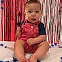 Waylon is registered to the contest to win money with this photo: baby, child, infant, red_overalls, striped_clothing, blue_shirt, sitting, barefoot, face, blue_eyes, curtains, red_backdrop, star_decorations, indoor, portrait, cute, festive, smiling, hands, feet