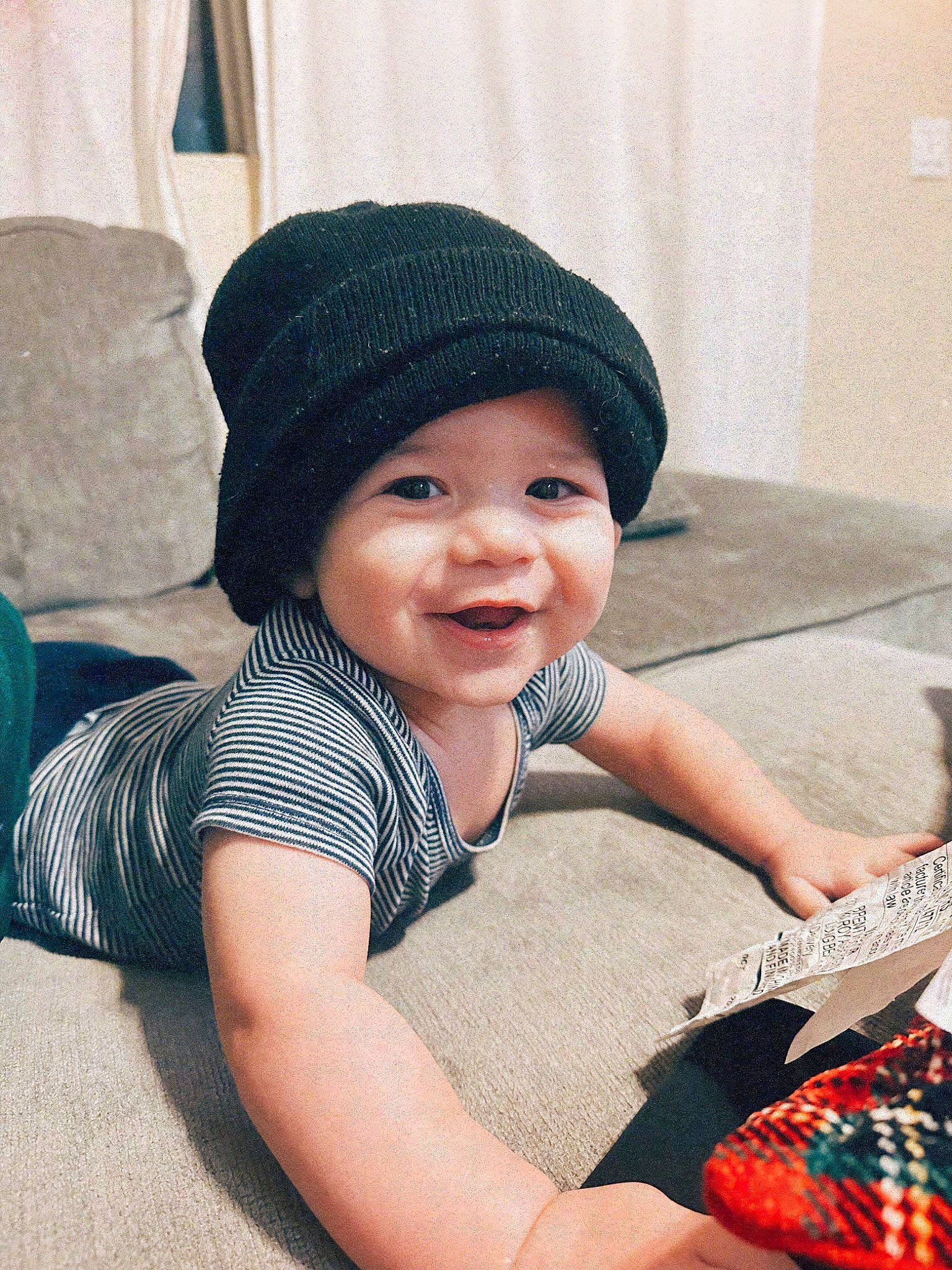 Luca is registered to the contest to win money with this photo: baby_toddler_clothing, cap, carmine, child, comfort, cool, fashion_accessory, floor, flooring, fun, happy, hat, headwear, human_leg, joy, knit_cap, pattern, person, sitting, smile