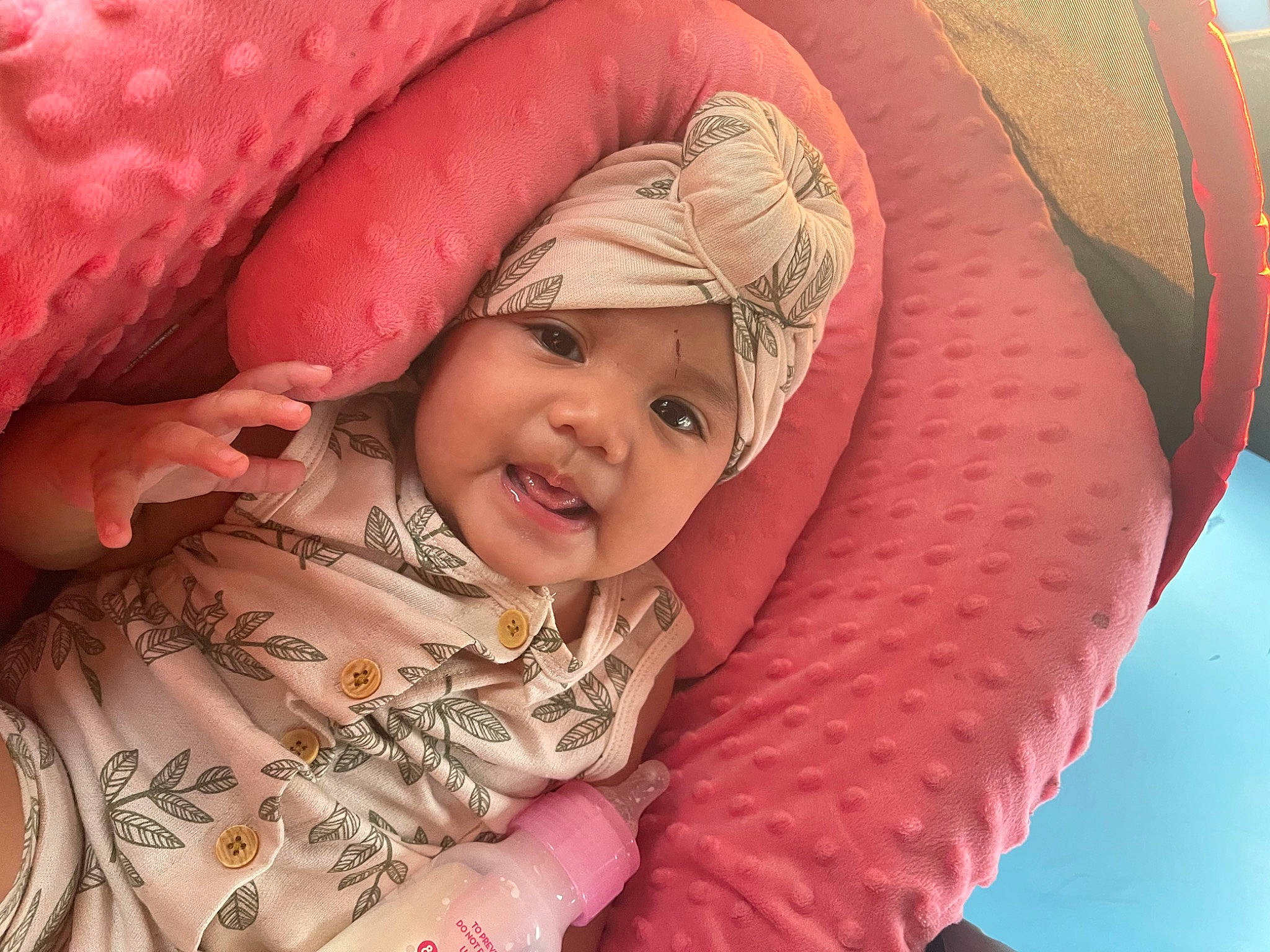 Aryah is registered to the contest to win money with this photo: baby, cheek, comfort, eye, facial_expression, finger, gesture, hand, happy, head, headwear, iris, leaf, lip, mouth, person, pink, product, skin, smile