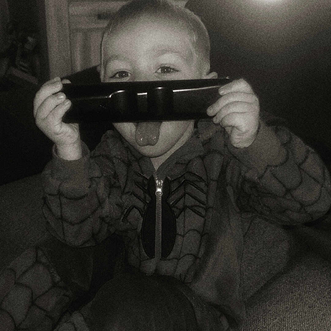 Daïron a rejoint le concours — aidez-le/la à gagner de superbes lots ! black_and_white, casual, child, childhood, couch, cozy, cute, fun, furniture, home, indoors, living_room, onesie, playful, portrait, relaxing, remote_control, smiling_eyes, spiderman_costume, tongue_out