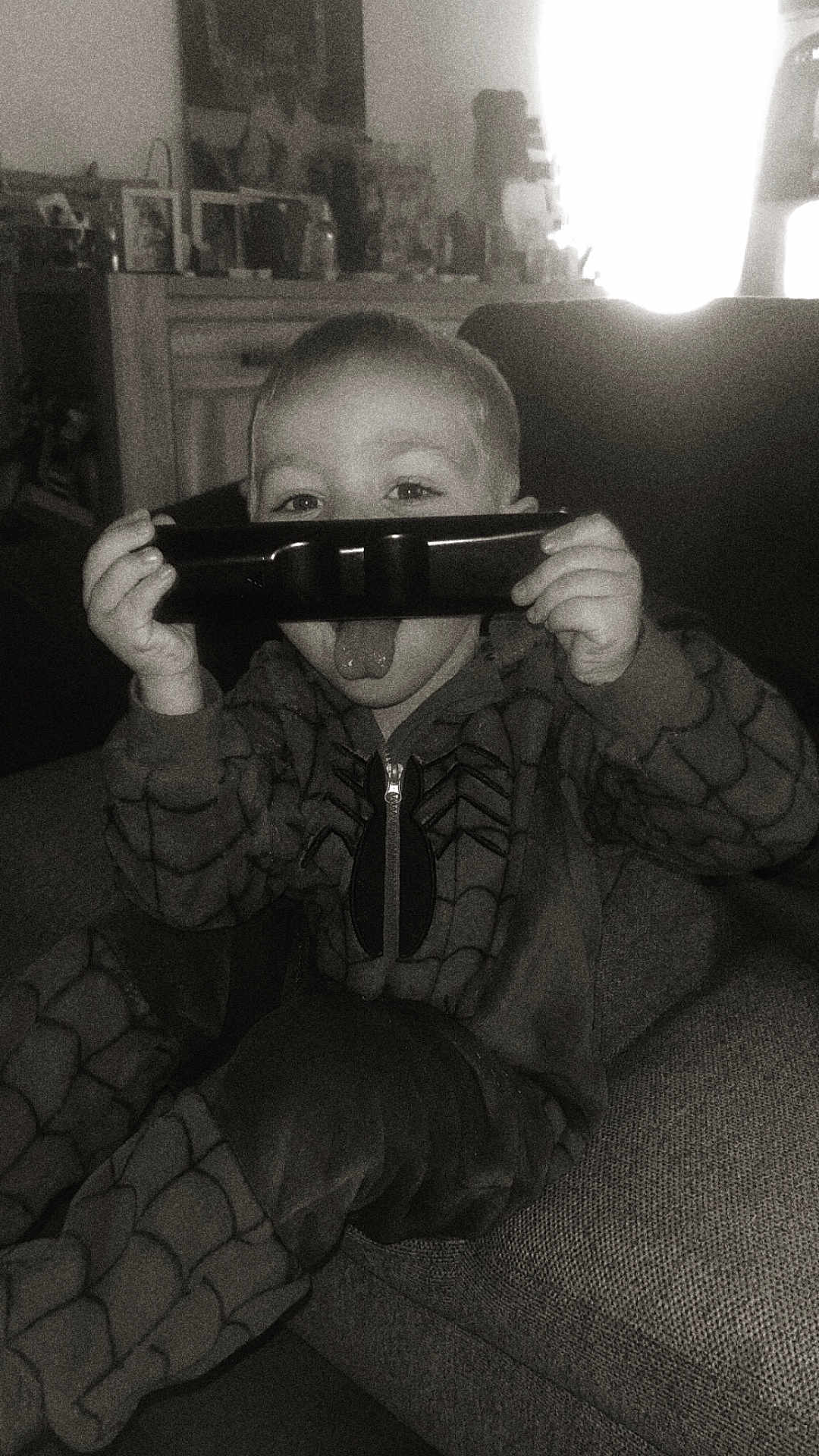 Daïron a rejoint le concours — aidez-le/la à gagner de superbes lots ! child, remote_control, tongue_out, spiderman_costume, onesie, couch, living_room, playful, indoors, furniture, childhood, casual, smiling_eyes, home, cozy, relaxing, portrait, black_and_white, cute, fun