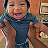 baby, child, smiling, happy, hoodie, shorts, animal_print, hands, kitchen, countertop, cabinet, microwave, person, infant, playful, portrait, indoor, cute, expression, holding