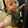 Jayce is registered to the contest to win money with this photo: toddler, child, indoor, carpet, green_shirt, reaching_hand, face, blue_eyes, blond_hair, person, baby, furniture, floor, candid, portrait, casual_clothing, curious, cute, young_child, home