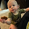 Jayce joined the competition — help win amazing prizes! toddler, child, cookie, carpet, car_seat, drool, blond_hair, green_shirt, indoor, carpeted_floor, warning_label, hand, blue_eyes, curious, sitting, young_child, candid, person, baby, home