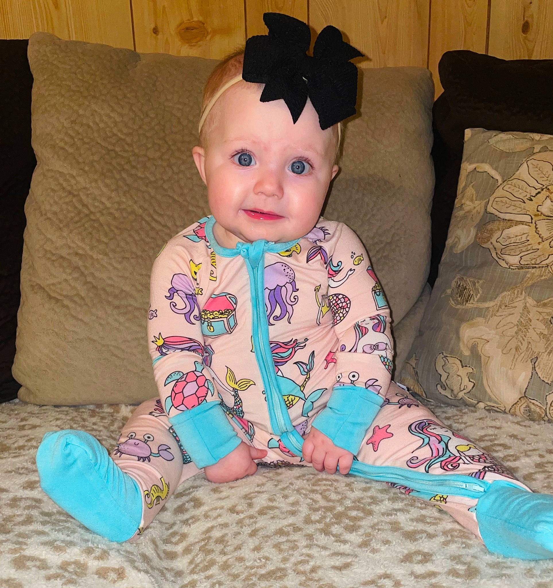 Emmalyn is registered to the contest to win money with this photo: baby, baby_toddler_clothing, cheek, child, comfort, couch, eye, face, flooring, happy, head, pattern, person, pink, product, skin, sleeve, smile, t_shirt, textile