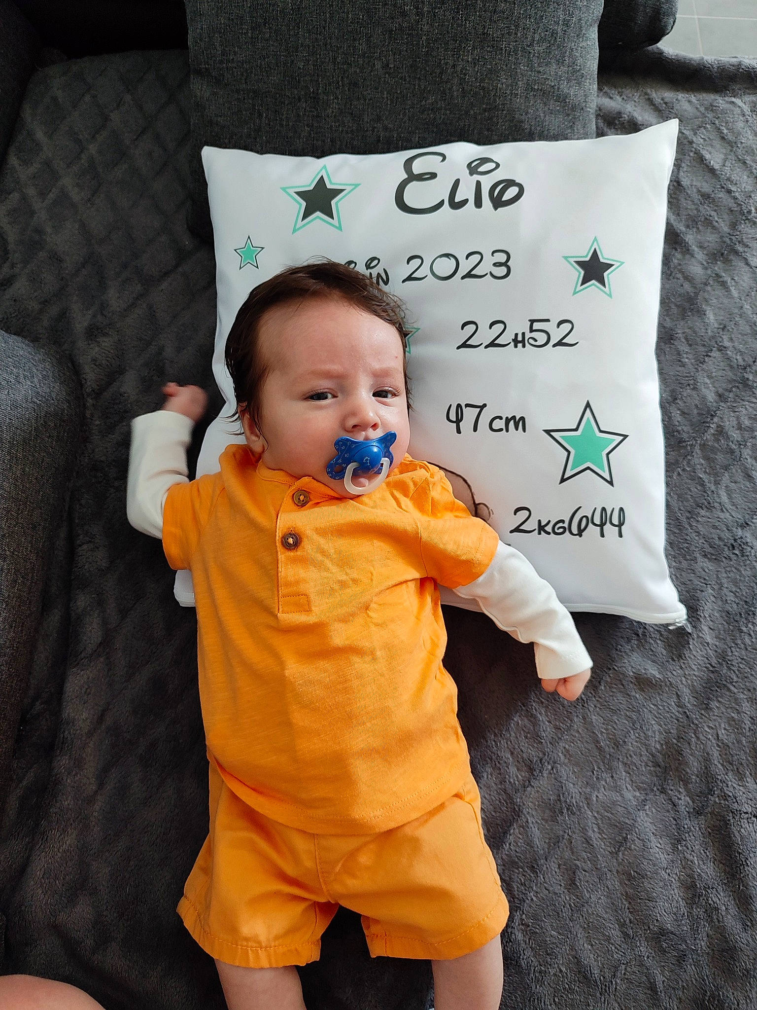 Élio participe au concours pour gagner de l'argent avec cette photo : baby, baby_toddler_clothing, child, event, flooring, font, fur, gesture, happy, linens, orange, peach, person, personal_protective_equipment, room, sleeve, t_shirt, textile, throw_pillow, toddler