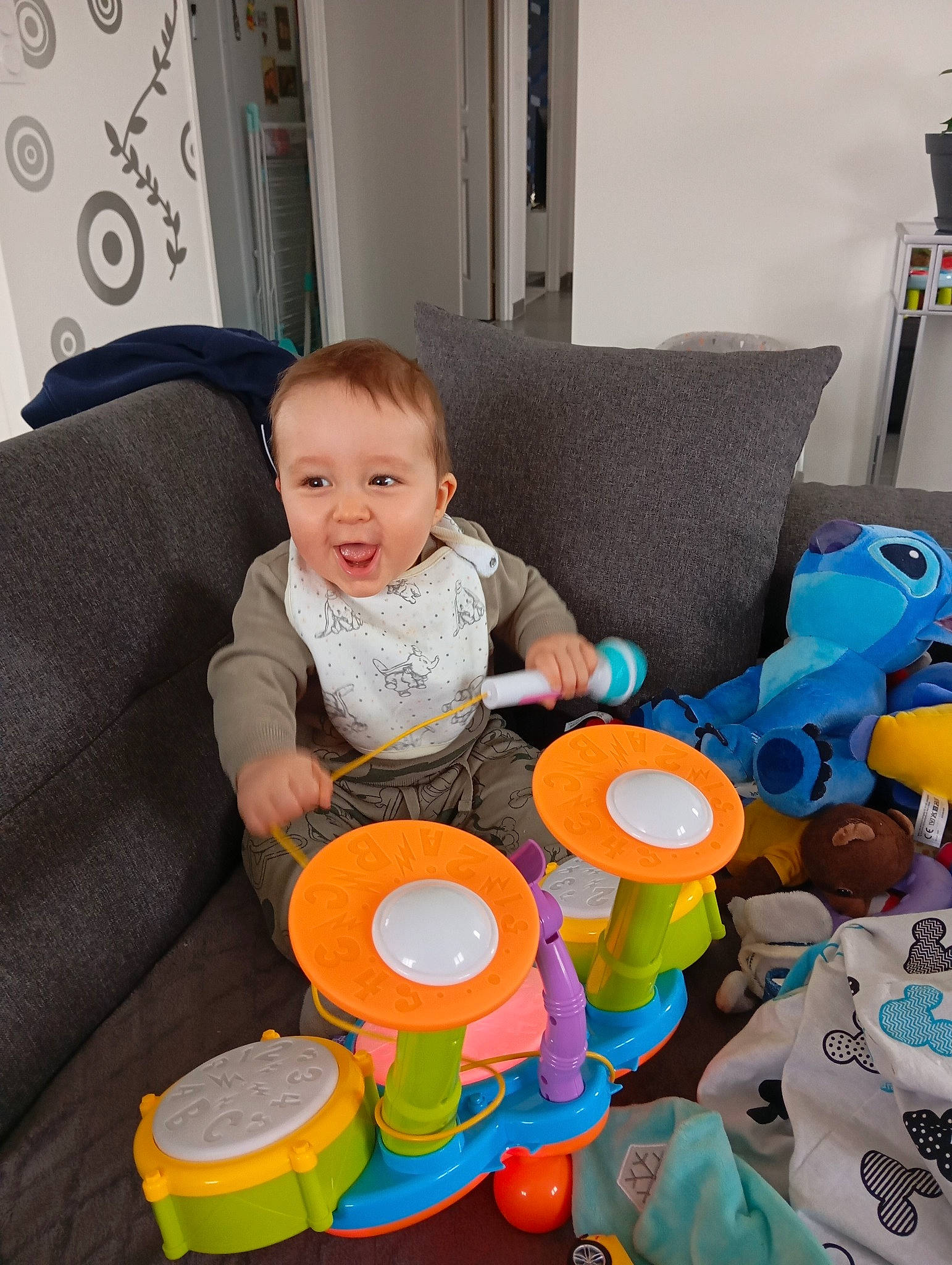 Élio participe au concours pour gagner de l'argent avec cette photo : baby, baby_playing_with_toys, baby_products, baby_toddler_clothing, baby_toys, chair, child, circle, comfort, couch, fun, leisure, person, picture_frame, play, room, sharing, sitting, smile, t_shirt