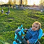 Florentin participe au concours pour gagner de l'argent avec cette photo : toddler, child, tricycle, denim_jacket, curly_hair, outdoor, grass, fence, geese, sunlight, yard, greenery, animal, pet, play, daylight, person, nature, baby, curious