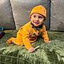 Florentin participe au concours pour gagner de l'argent avec cette photo : toddler, child, pumpkin_costume, orange_clothing, crawling, green_couch, gray_cushions, indoor, toy, wooden_toy, face, expression, curious, mischievous, hat, footwear, plush_texture, person, smile, home