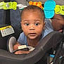 baby, infant, car_seat, toy, child, face, curious, indoors, seat_belt, clothing, black_hair, wide_eyes, playing, close_up, young_child, cute, looking, person, head, baby_toys