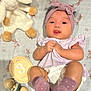 baby, infant, headband, socks, blanket, stuffed_animal, toy, rattle, milestone_card, lying_down, tongue_out, cute, pink, purple, wooden_toy, bunny_pattern, child, soft_toy, playful, clothing