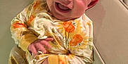 Dafne joined the competition — help win amazing prizes! baby, child, pajamas, sunflower_pattern, smiling, happy, couch, indoor, person, sitting, cute, infant, face, hand, furniture, cozy, skin, head, expression, comfort