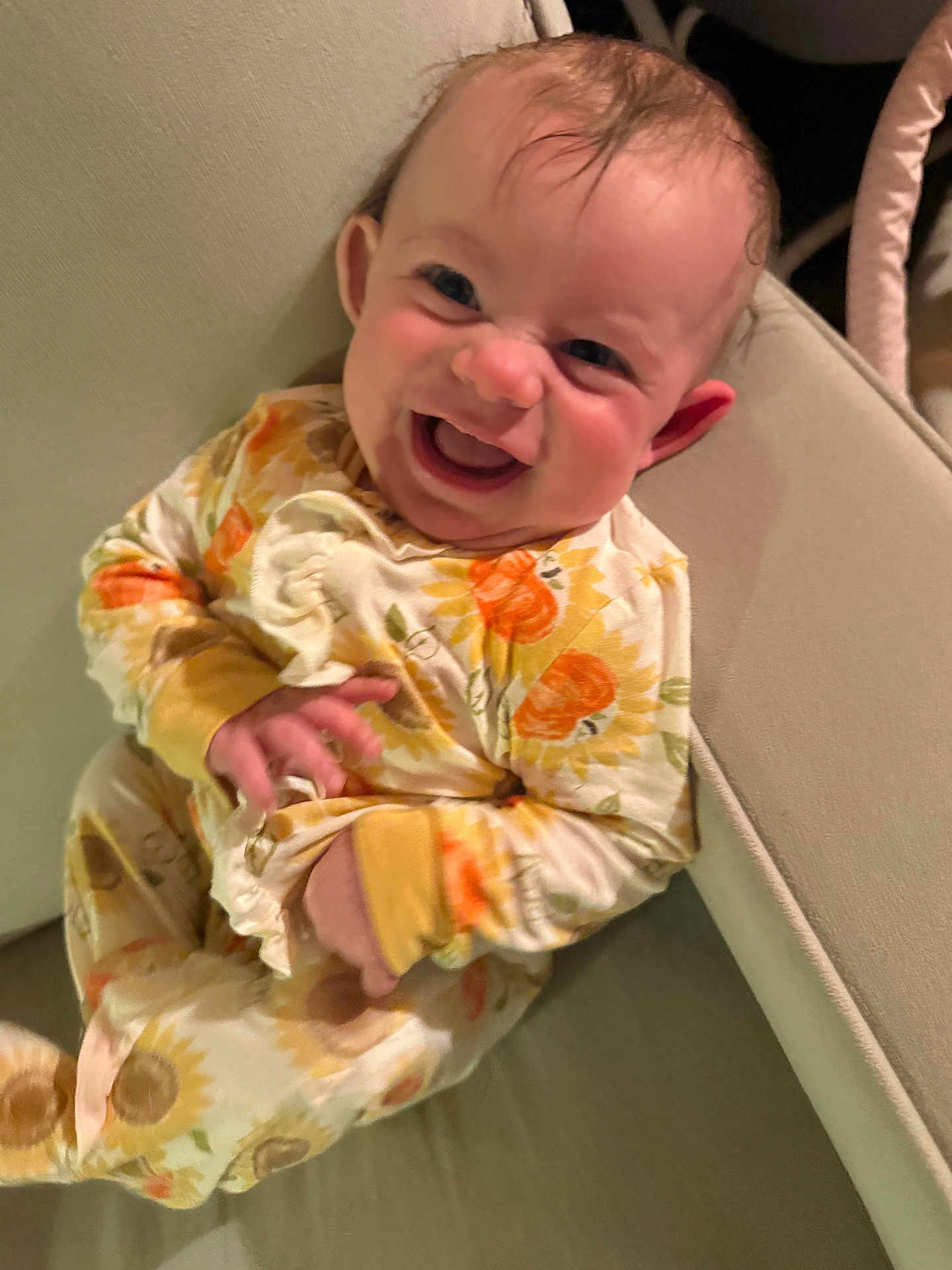 Dafne joined the competition — help win amazing prizes! baby, child, pajamas, sunflower_pattern, smiling, happy, couch, indoor, person, sitting, cute, infant, face, hand, furniture, cozy, skin, head, expression, comfort